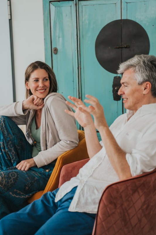 Zwei Personen sitzen jeweils in einem Sessel und sprechen miteinander.